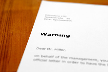 A letter on a wooden table - warning