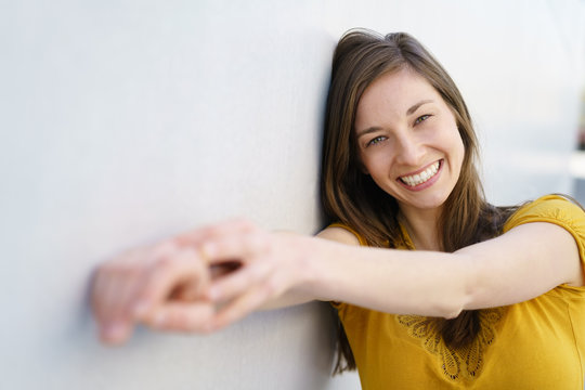 Cheerful young woman holding out hands to camera