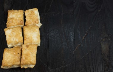 Pastries, puff biscuits against the black burnt tree