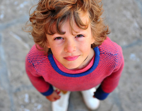 Shaggy Boy In Pink Jersey Looking At Camera