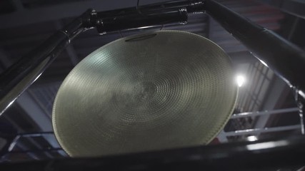 Native gong Hand with hammer banging a native golden gong.