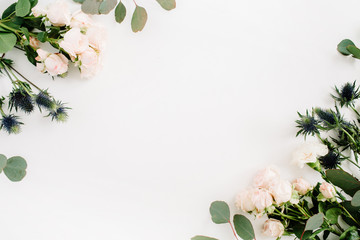 Fototapeta premium Granicy rama robić beżowi różani kwiaty, eringium kwiat, eukaliptus rozgałęzia się na białym tle. Płaski układ, widok z góry. Tło kwiatowy