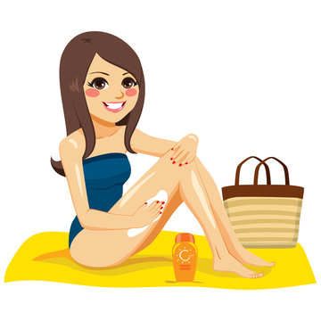 Beautiful young happy brunette woman applying suntan cream on her legs sitting in yellow towel