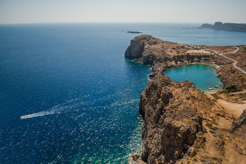 View of the harbor and the beach town of Lindos, the Acropolis, the beach with yachts and blue sea