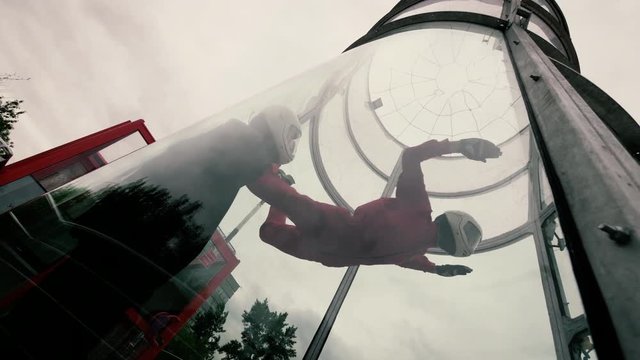 Girl paratrooper performing a parachute jumping in a wind tunnel