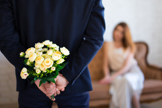 Valentine's Day Or Anniversary Concept - Man Hiding Flowers Behind His Back