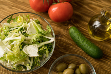 Salad ingridients. Tomato, lettuce, cucumber and olive oil.