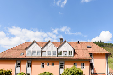 Renoviertes Haus mit Dachgauben vor blauem Himmel