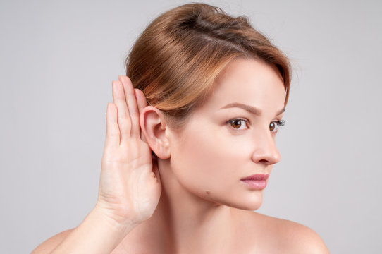  Woman hold hand near her ear and listening carefully