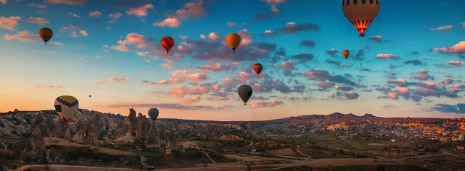 Fototapeten Sonnenaufgang und fliegende Heißluftballons über dem Tal Kappadokien, Türkei. © ValentinValkov