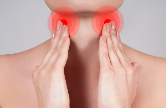 Young woman has sore throat touching the neck