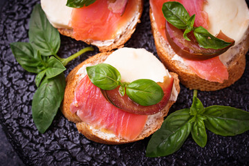 Crostini with salmon, mozarella, tomato and basil