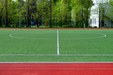 football field with artificial turf, central circle, background