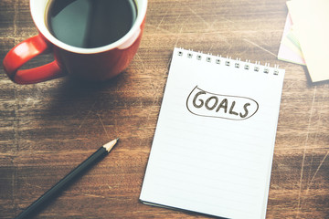 goals text on paper with cup of coffee