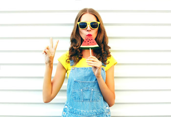 Fashion cool girl eating a slice of watermelon in the form of ice cream on a white background © rohappy
