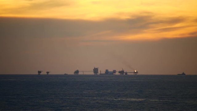 Central processing platform (cpp) in the middle of the ocean during sunset time - upstream industry