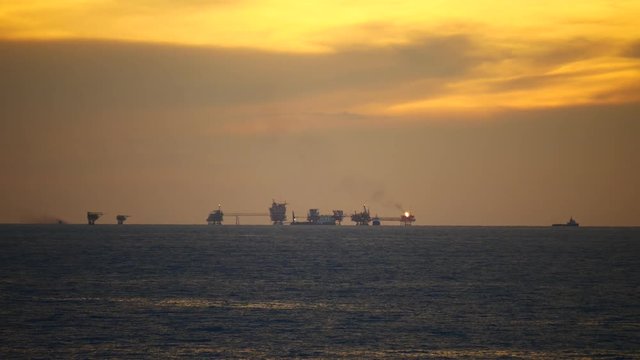 Central processing platform (cpp) in the middle of the ocean during sunset time - upstream industry