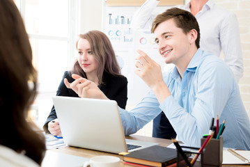 Happy businessman discussing work with his colleagues in the office