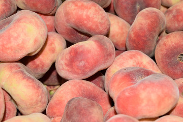 Closeup of fresh and juicy flat peaches