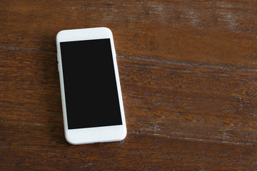 White smart phone with black screen on Wood background