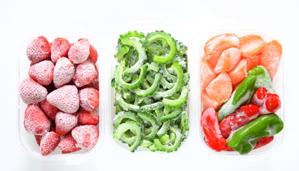 保存容器に入れた冷凍野菜、冷凍フルーツ、ホームフリージング、白背景