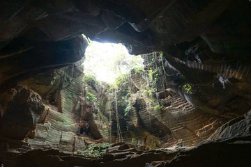 Old abandoned caves for mining of limestone with sun ray in dark enviroment in the Arosbaya, madura region in Indonesia