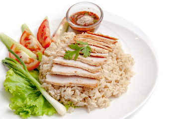 Roasted pork over rice served with vegetable and chili sauce