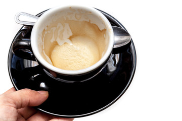 Stain of coffee in black cup on white background isolated