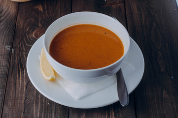 Vegetarian food concept. Lentil cream soup in white plate on wooden background table. Copy space. Healthy eating