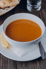 Vegetarian food concept. Lentil cream soup in white plate on wooden background table. Copy space. Healthy eating