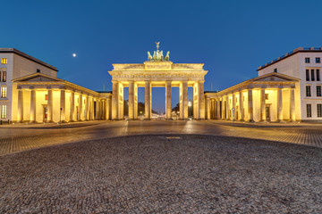 Fototapeta premium The famous Brandenburg Gate in Berlin illuminated at dawn
