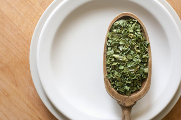 Dried chive in wooden spoon