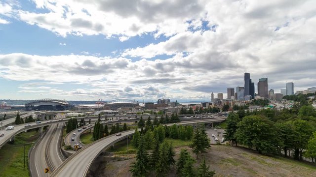 Time lapse movie of white clouds and blue sky over Seattle Washington downtown city skyline and interstate freeway auto traffic 4k ultra high definition uhd