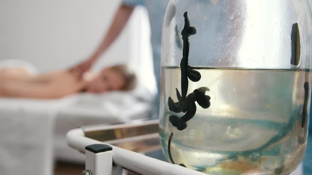 Bank with leeches against the background of a blurry girl who lies on her stomach