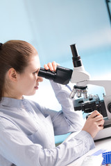 Fototapeta premium Doctor woman working a microscope. Female scientist looking through a microscope in lab. Student girl looking in a microscope, science laboratory concept