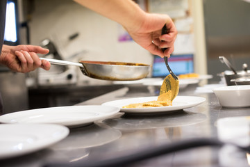 Chef serving Italian pasta in a restaurant kitchen