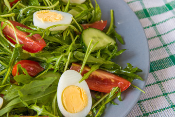 Fresh green salad with arugula, tomatoes, eggs and cucumber