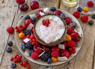 Coconut half with yogurt and healthy fruit salad