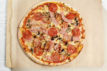 Pizza italian with bacon and salami on a paper.