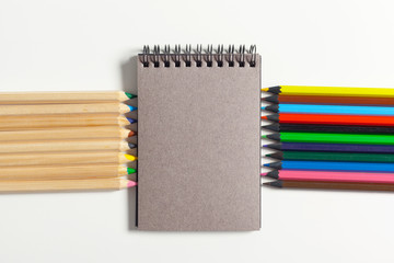 Obraz premium colored pencils and notepad on the table