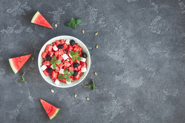 Watermelon salad and watermelon slices on black background. Top view, flat lay, copy space