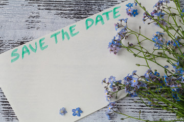 The forget-me-not branch on a card with pgrase save the date