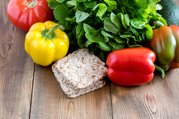 Fresh vegetables on wooden background Beautiful Yellow and red raw peppers Food for fasting days Ingredients for salad Crisp bread Diet or vegetarian food concept
