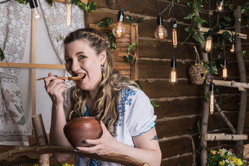 Ugly woman in national dress posing in a rustic interior