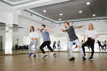 Group of young modern dancers dancing in the studio. Sport, dancing and urban culture concept