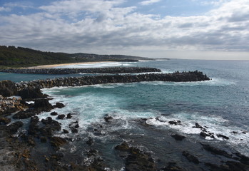 Breakwaters at Narooma (NSW, Australia) on a cloudy day. Dam rock for protecting the sea erosion. The entrance of Wagonga Inlet. View from Bar Rock lookout.