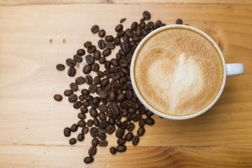 Latte art with coffee beans on wood table