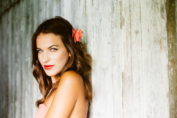 Obraz premium Sexy attractive brunette woman fashion model over old barn wood wall background, portrait
