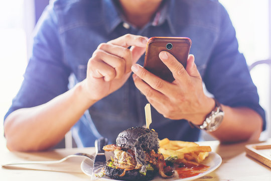 man capturing food picture before breakfast by smartphone