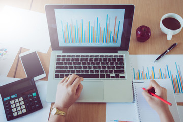 Close-up businessman working with sheet analysis charts on the desk.